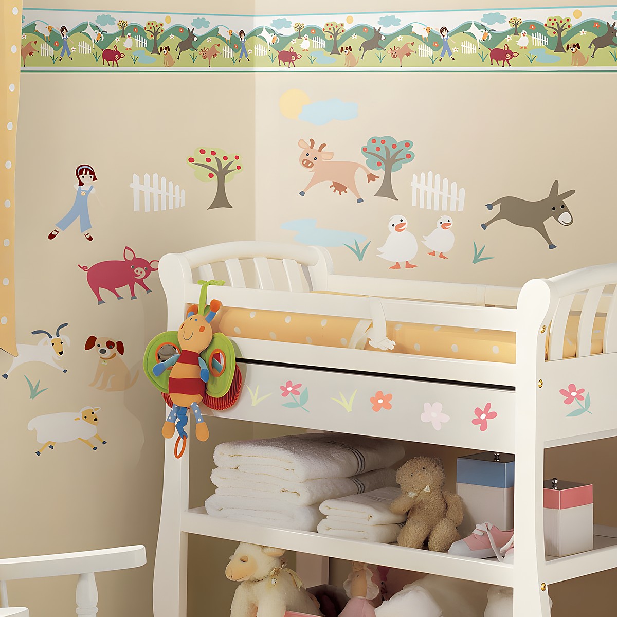 RoomMates Bordüre Gem's Friends Farm, illustrierter Bauernhof-Bordürenstreifen mit Tieren und Bäumen über Bauernhoftier-Wandstickern an einer beigen Kinderzimmerwand