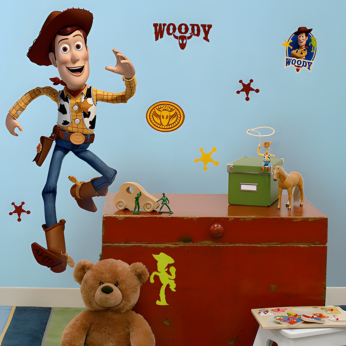 RoomMates Wandbild Disney Pixar Toy Story Woody, Woody in springender Pose mit Cowboyhut an einer blauen Kinderzimmerwand über einer roten Truhe mit Teddybär