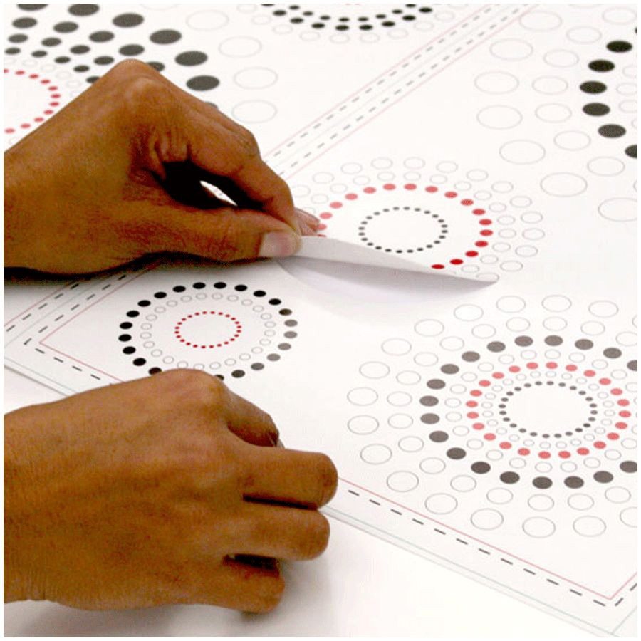 RoomMates wall decal Fusion Peel & Stick, hands peeling a dot circle motif off the backing sheet, usage example