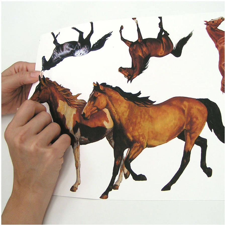 RoomMates wall decal Wild Horses, hands peeling a brown horse motif off the backing sheet, usage example