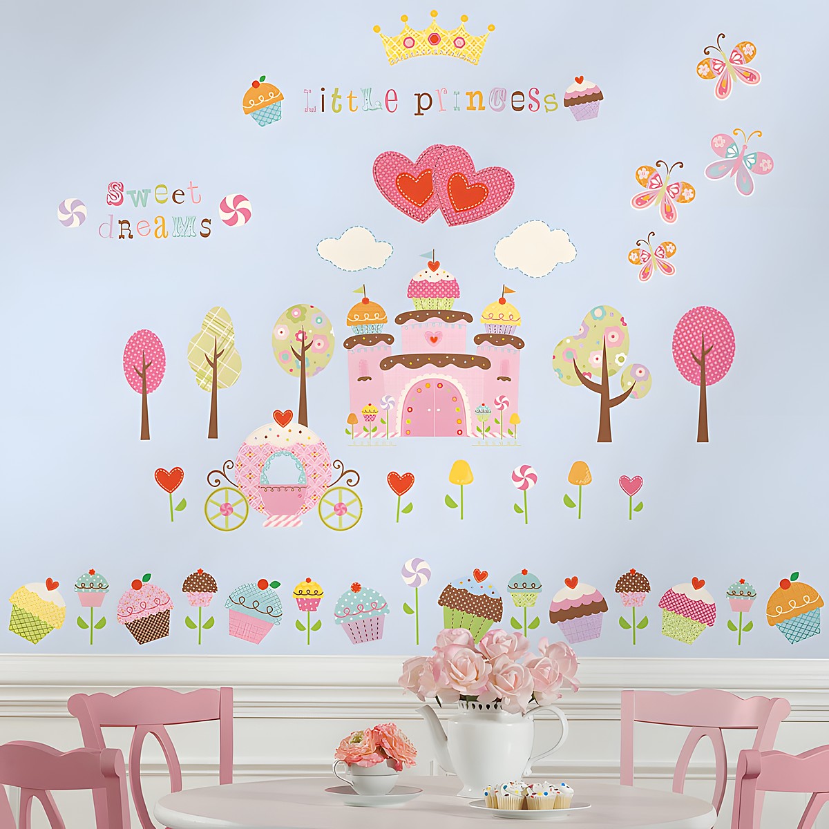 RoomMates Wandsticker Cupcake Castle, Schloss- und Cupcake-Motive mit „Little Princess“-Schriftzug und Schmetterlingen an einer hellblauen Kinderzimmerwand über einem Tisch