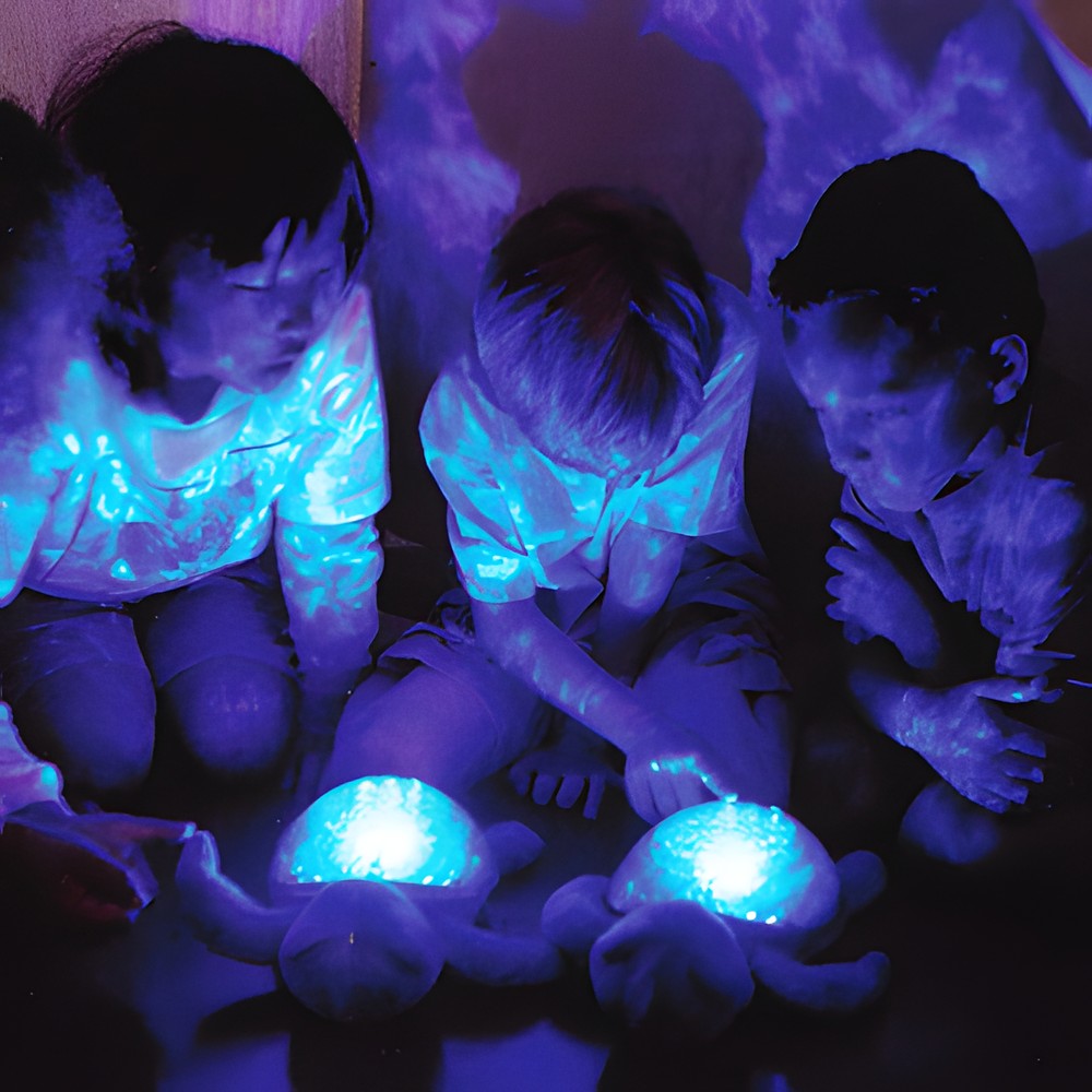 Cloud b sleep aid Tranquil Turtle Ocean, lifestyle photo with several children and glowing plush turtles