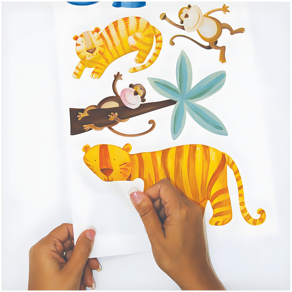 RoomMates Wandsticker Jungle Adventure, Hände lösen ein Tiger-Motiv vom Trägerbogen, Anwendungsbeispiel