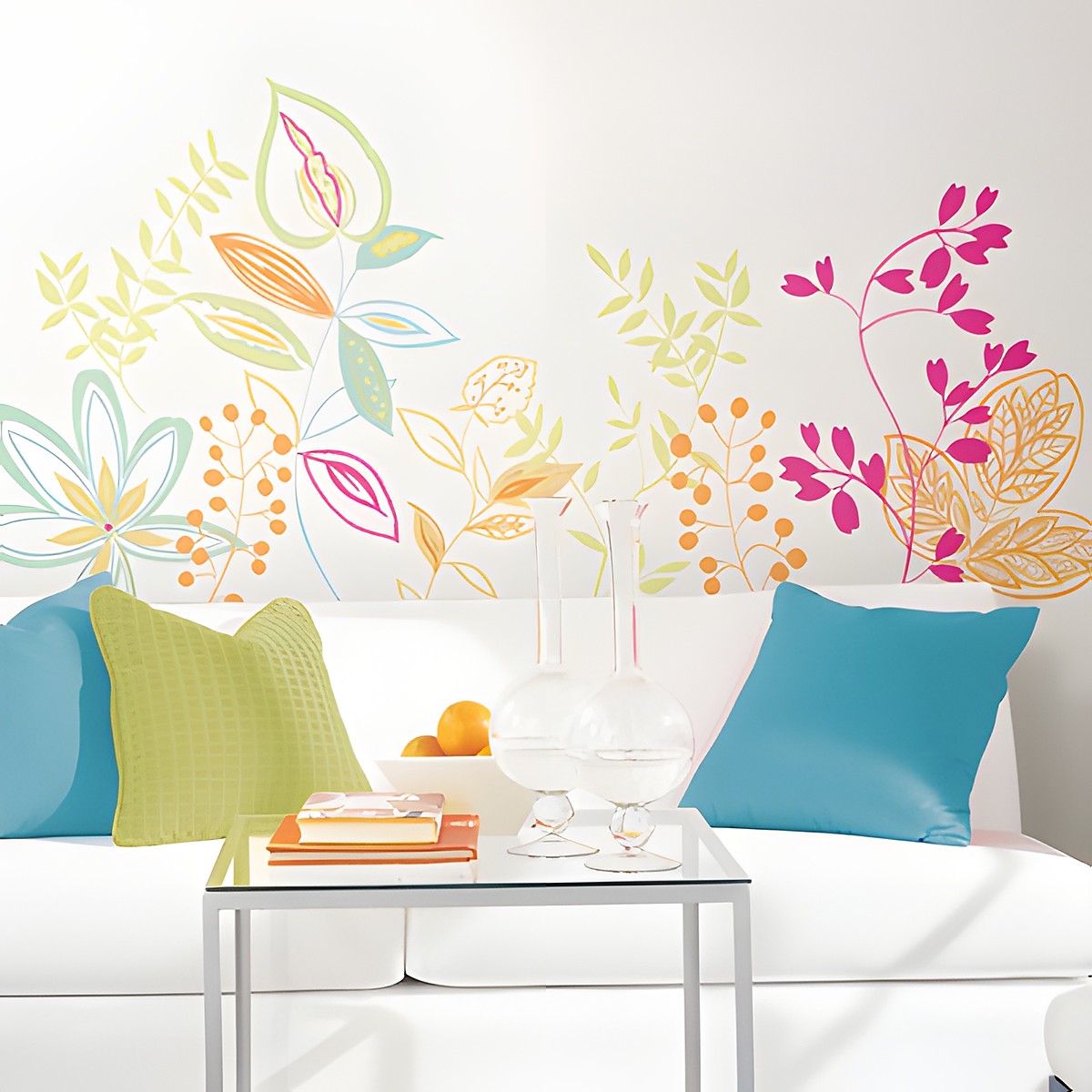 RoomMates Wandbild Graphic Leaves, bunte grafische Blätter- und Blütenranken in Grün, Pink und Orange an einer weißen Wand über einem Sofa