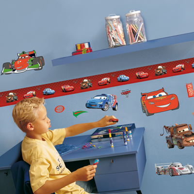 decofun wall decoration Pixar Cars 2 on a blue children's room wall with a red border, boy at a desk with race car Francesco Bernoulli above