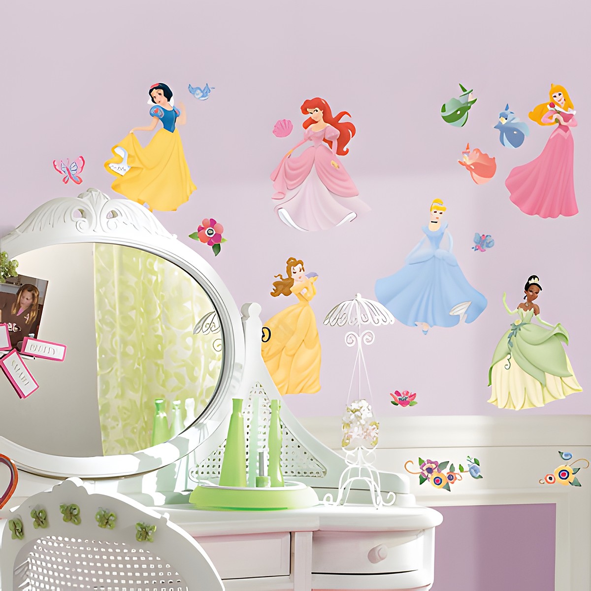 RoomMates Wandsticker Disney Princess, Motive mit Schneewittchen, Arielle, Aurora, Belle, Cinderella und Tiana an einer violetten Kinderzimmerwand über einer Frisierkommode