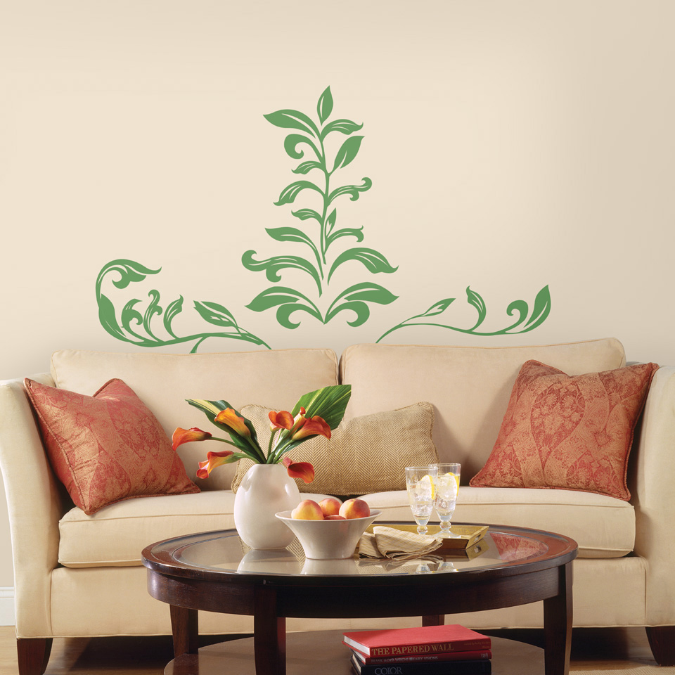 RoomMates wall decal Leaf Scroll Peel & Stick, green leaf vine motif on a cream-coloured wall above a sofa