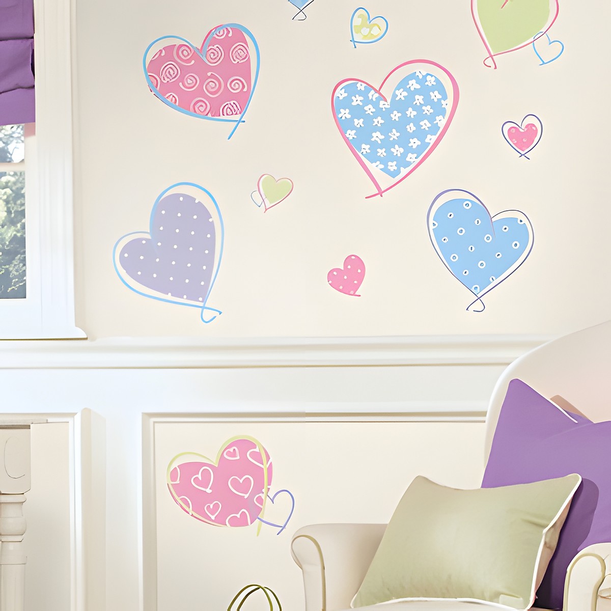 RoomMates Wandsticker Hearts, gemusterte Herzmotive in Pink, Blau, Lila und Grün an einer cremefarbenen Wand über einem Sessel