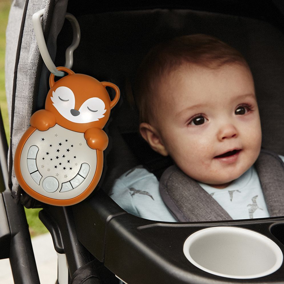 Cloud b sleep aid Sweet Dreamz on the Go fox, lifestyle photo of device clipped to stroller, baby in background
