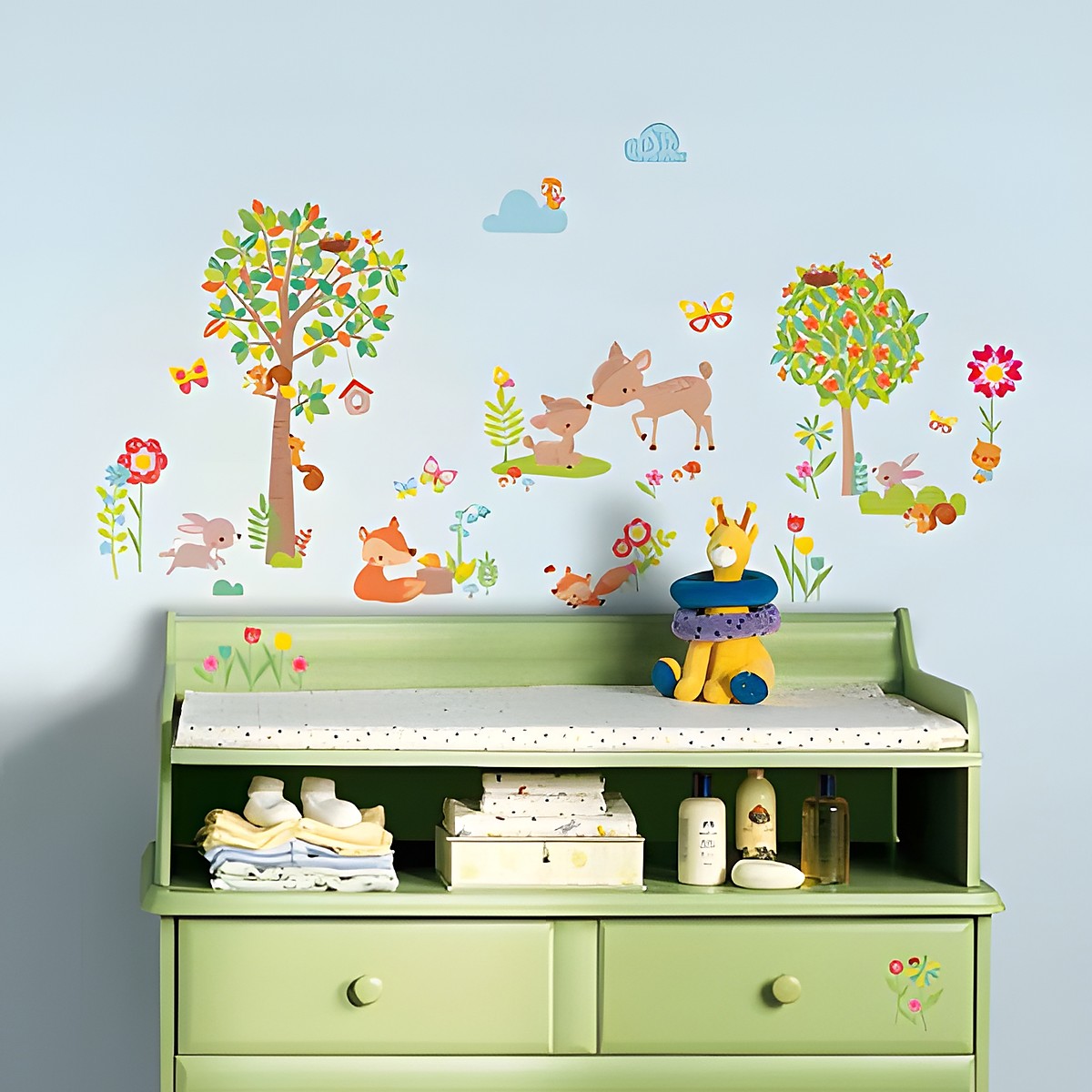 RoomMates Wandsticker Woodland Waldtiere, Waldtiere wie Reh, Fuchs und Eichhörnchen mit Bäumen und Blumen an einer hellblauen Kinderzimmerwand über einer Wickelkommode