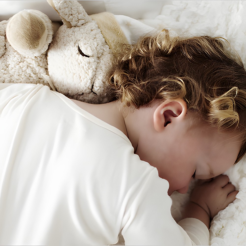 Cloud b Einschlafhilfe Schaf Sleep Sheep, Anwendungsfoto mit schlafendem Kind, das das Kuscheltier umarmt