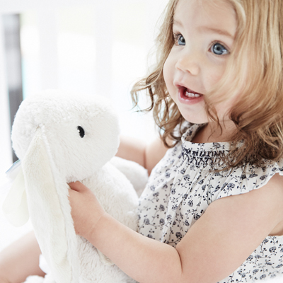 Cloud b sleep aid Bubbly Bunny, lifestyle close-up of toddler holding beige bunny plush