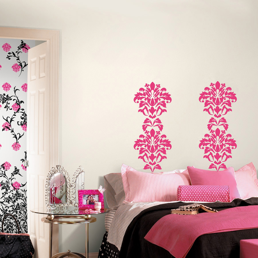 RoomMates wall decal Damask Pink, two pink damask ornaments on a cream-coloured wall above a bed with pink bedding