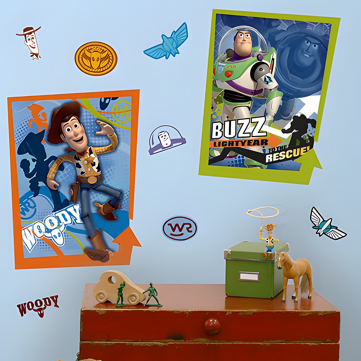 RoomMates Wandbild Toy Story Buzz Lightyear & Woody, Disney-Pixar-Motive mit Woody- und Buzz-Lightyear-Postern sowie kleinen Symbolaufklebern an einer hellblauen Kinderzimmerwand über einer roten Kommode