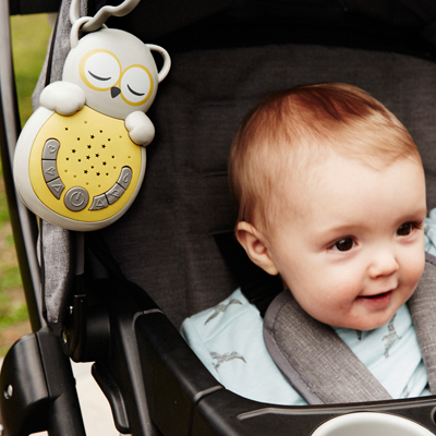 Cloud b sleep aid Sweet Dreamz on the Go owl, lifestyle photo of device clipped to stroller, baby in background